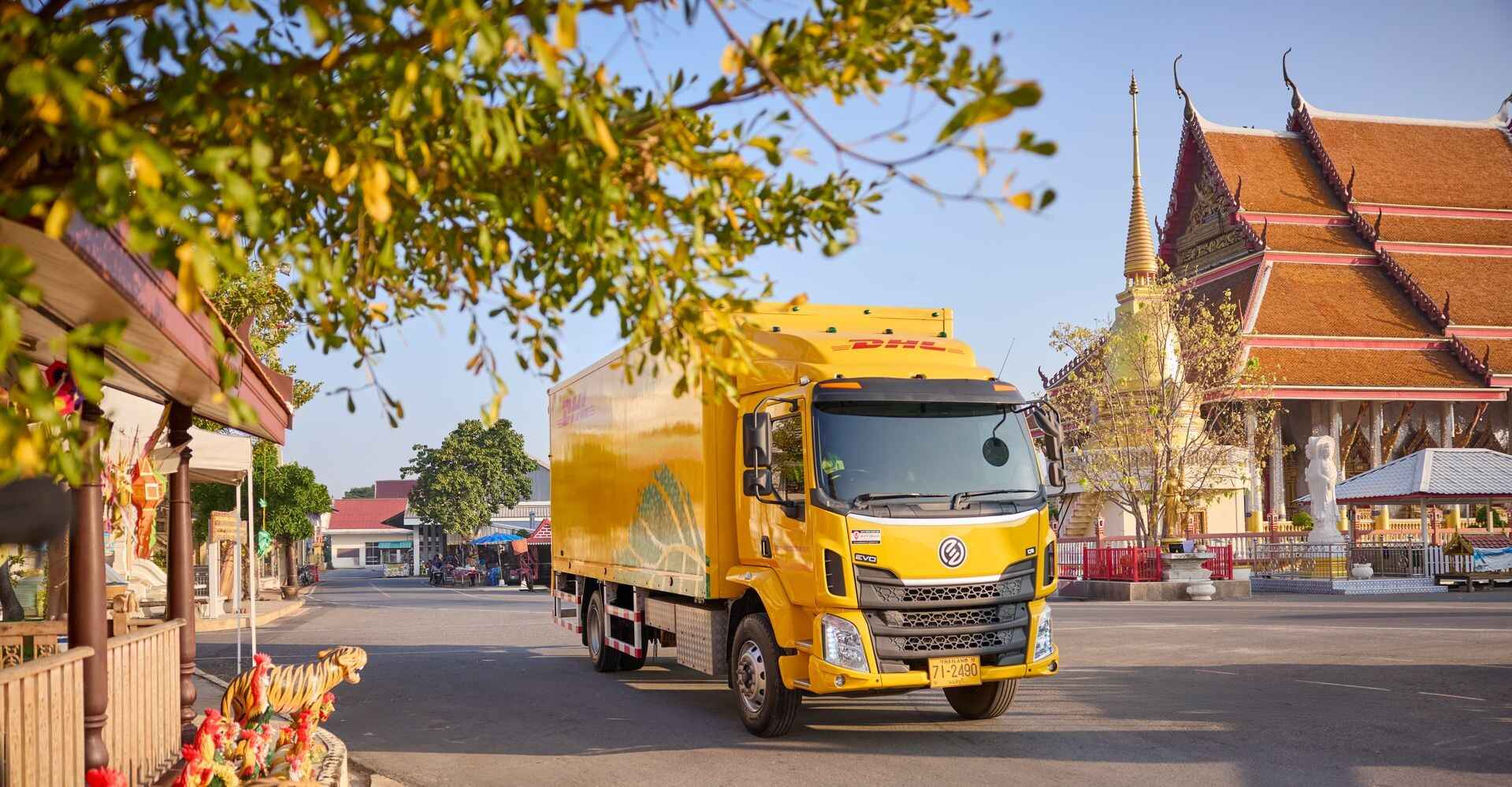 DHL truck passing by scenic temples.