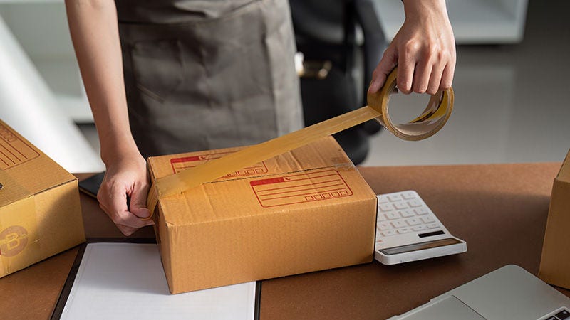 Entrepreneur sealing a box with packing tape