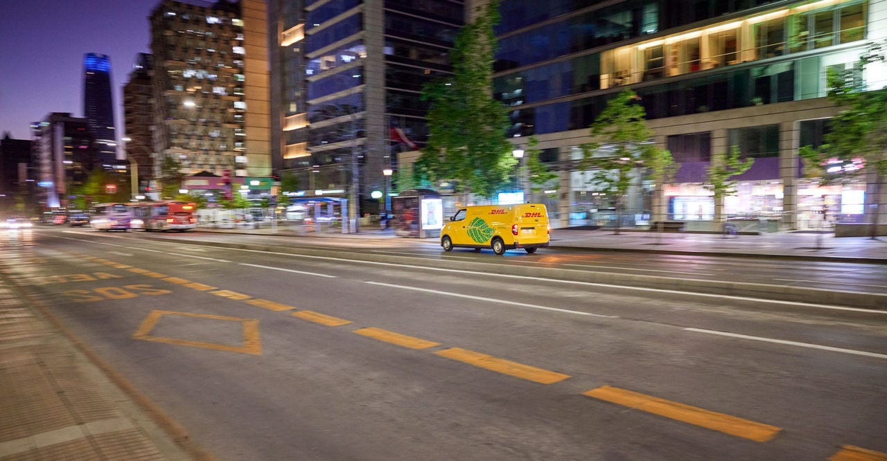在東南亞城市夜間行駛中的 dhl express 運務車