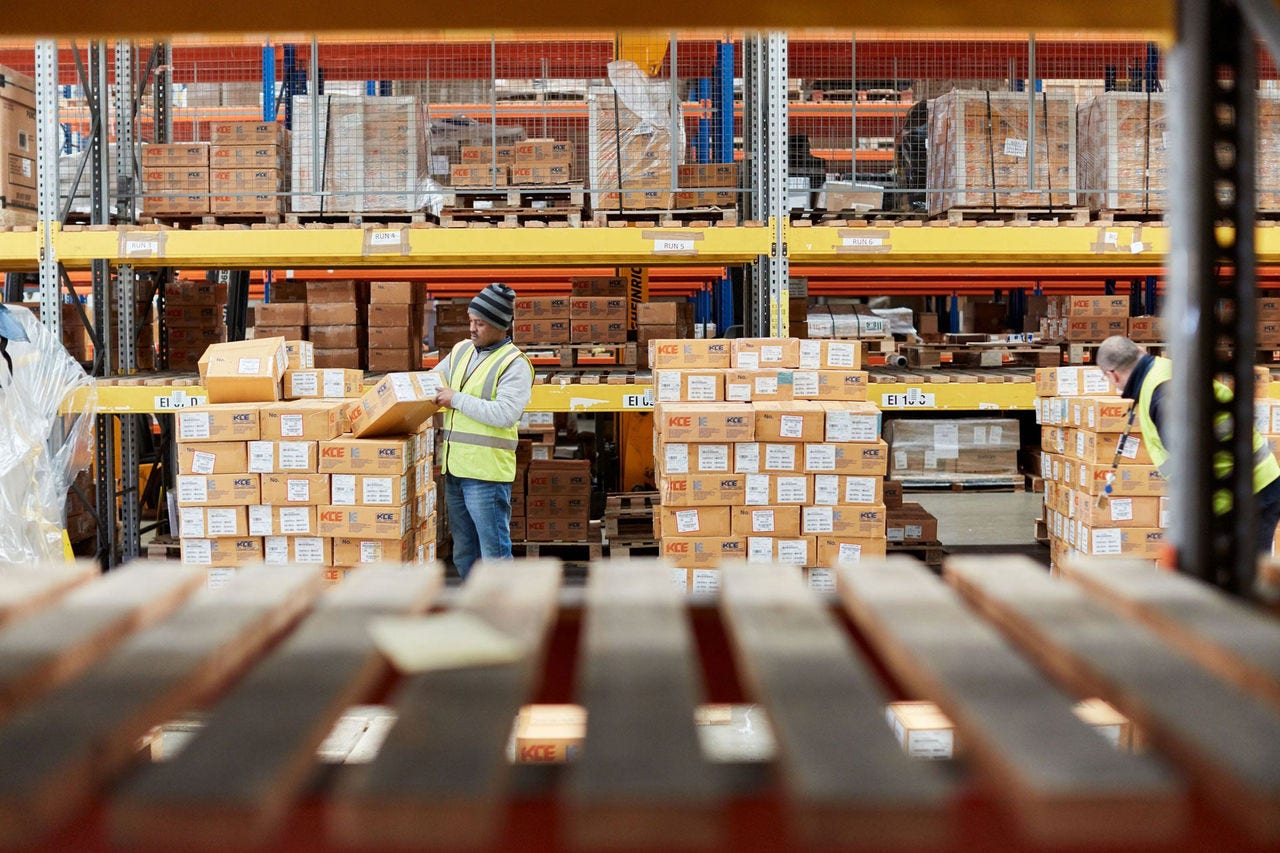 Warehouse with workers in yellow vests organizing boxes