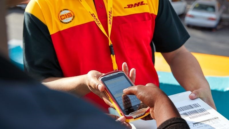 A customer signs a DHL Express scanner for delivery.