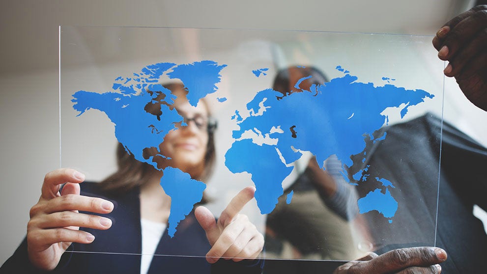 man and woman looking at map of the world