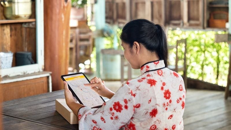 A dhl express employee from thailand collecting a parcel to be delivered to japan