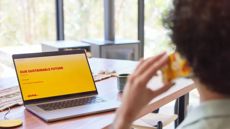 an entrepreneur on his phone, looking through dhl’s slides of a sustainable future