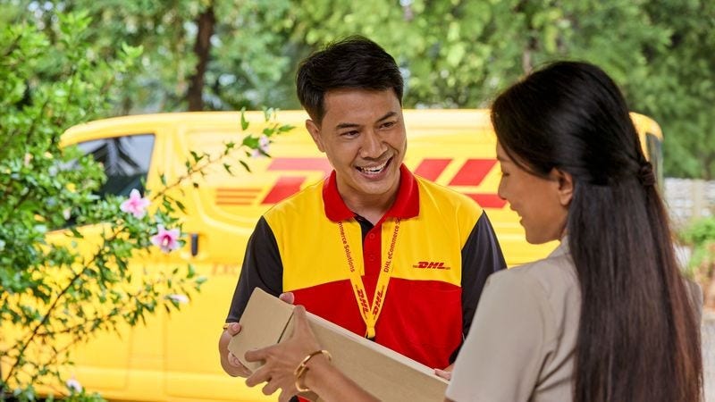 A DHL employee chatting with a happy customer.