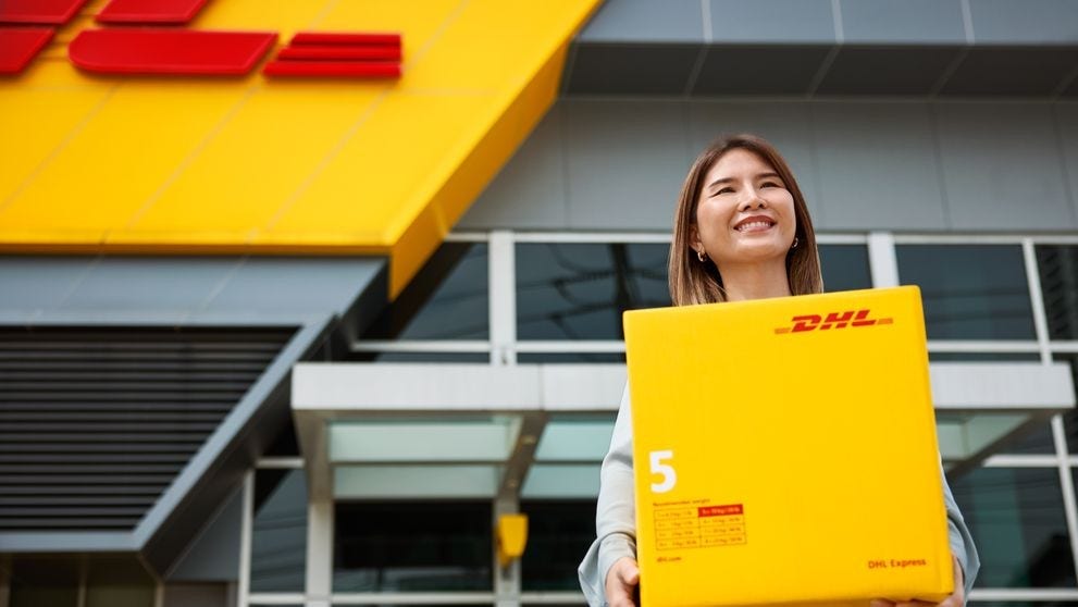 A DHL logistics personnel holding goods for delivery