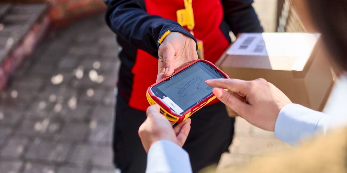 一位顾客正在扫描仪上签名，同时一位DHL员工拿着一个包裹。