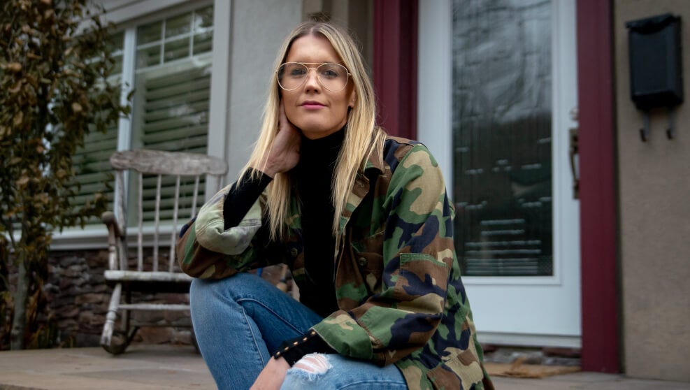 Emily O'Brien, fondatrice Comeback Snacks, une entreprise de maïs soufflé, pose sur les marches devant sa maison.