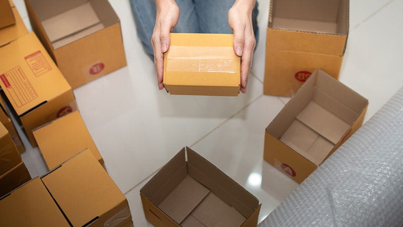 Small business owner placing a product inside a cardboard box