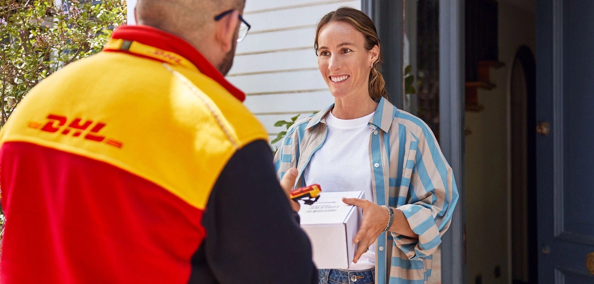 Entregador da DHL entrega uma encomenda na porta da cliente, o destino final de uma venda em DDP