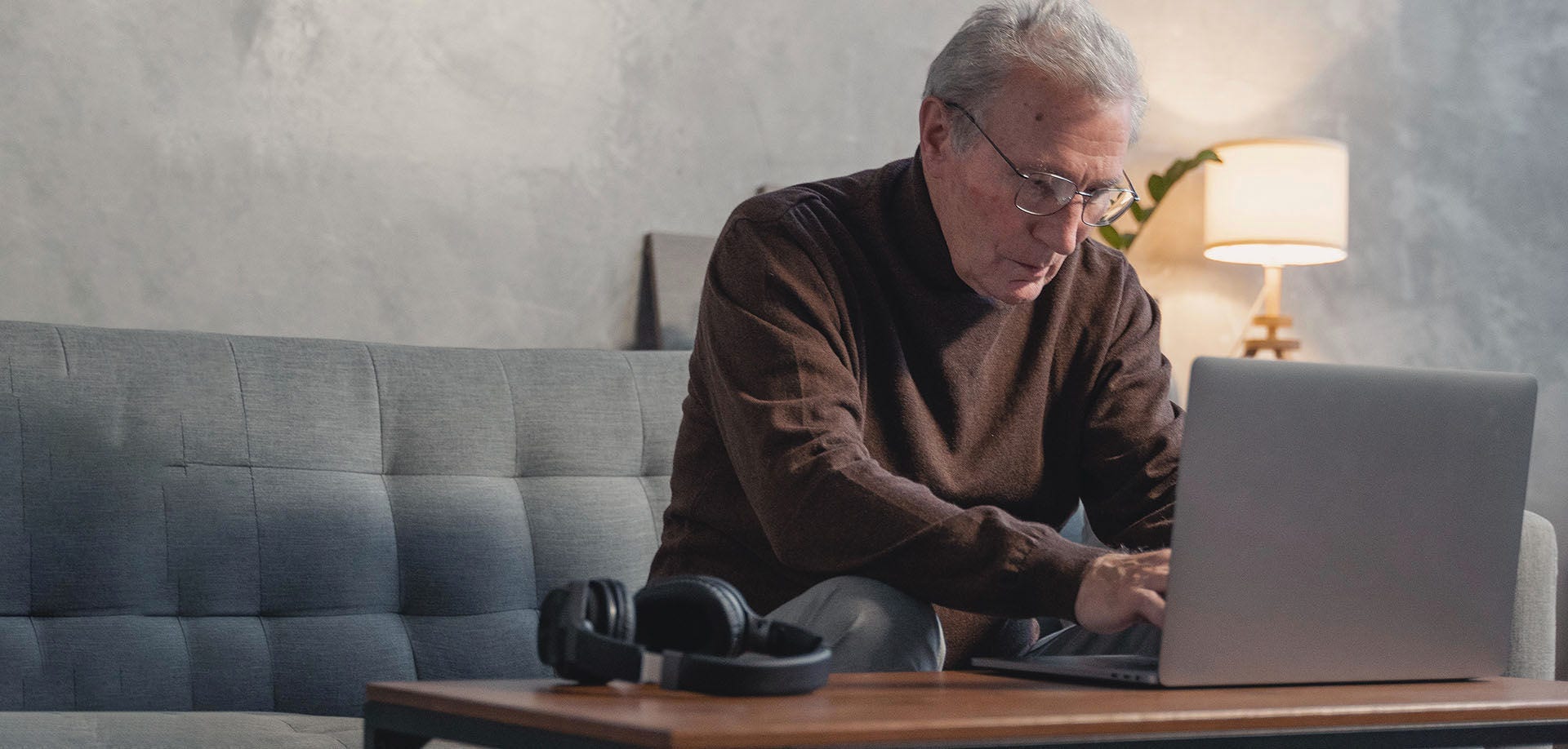 old man typing on laptop