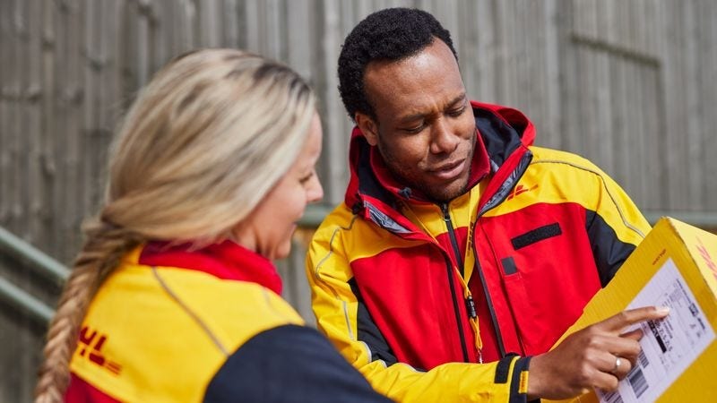 dhl express employees inspecting address label on parcel