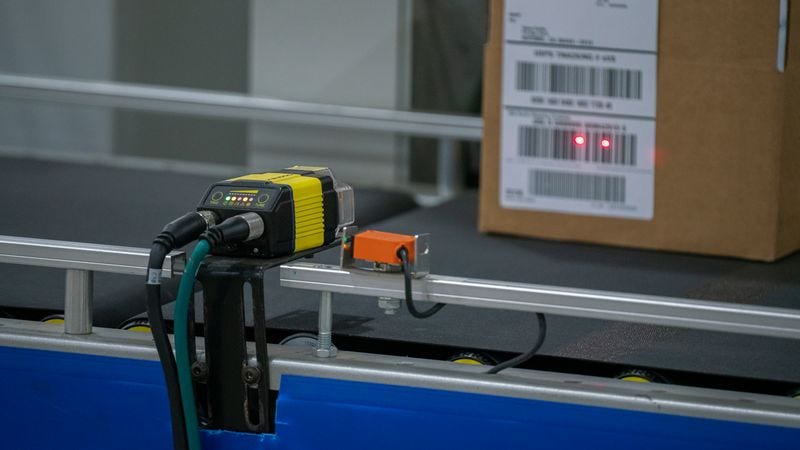 automated sorting machine scanning a package on a conveyor belt