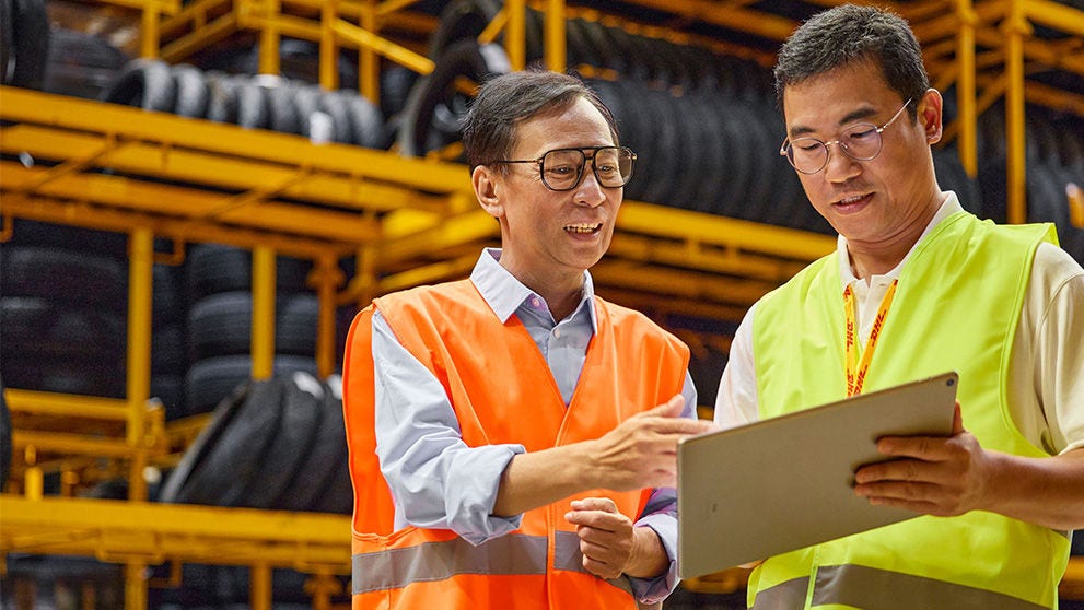 two Asian men looking at tablet screen