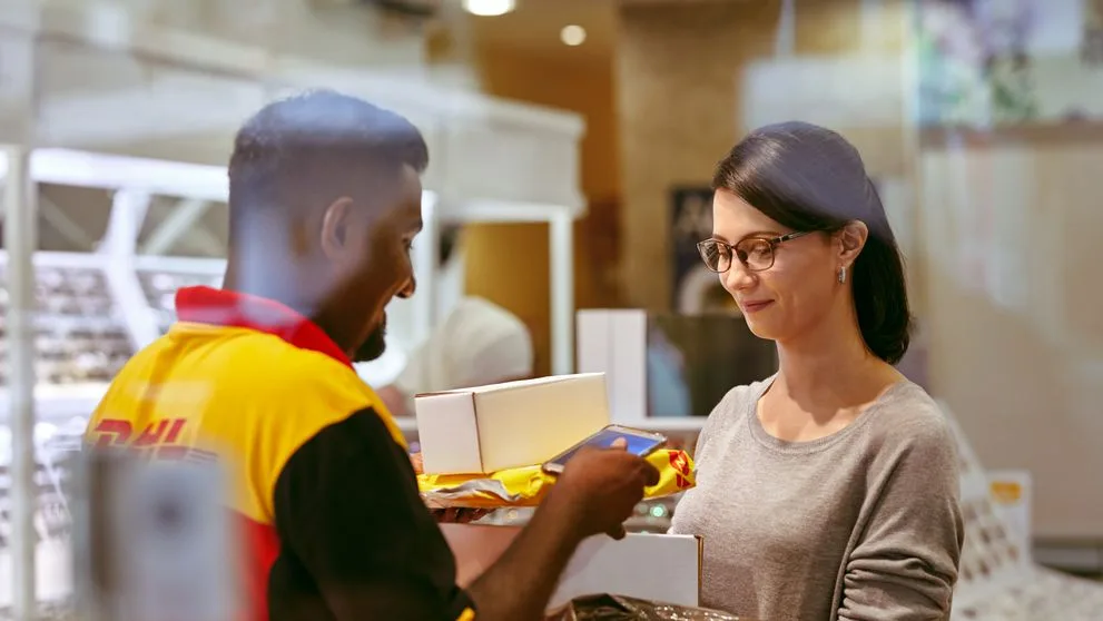 DHL delivery personnel engaged in conversation with a customer.