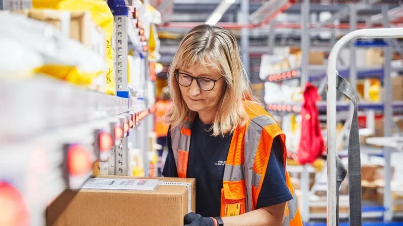 dhl express employee handling parcel in warehouse