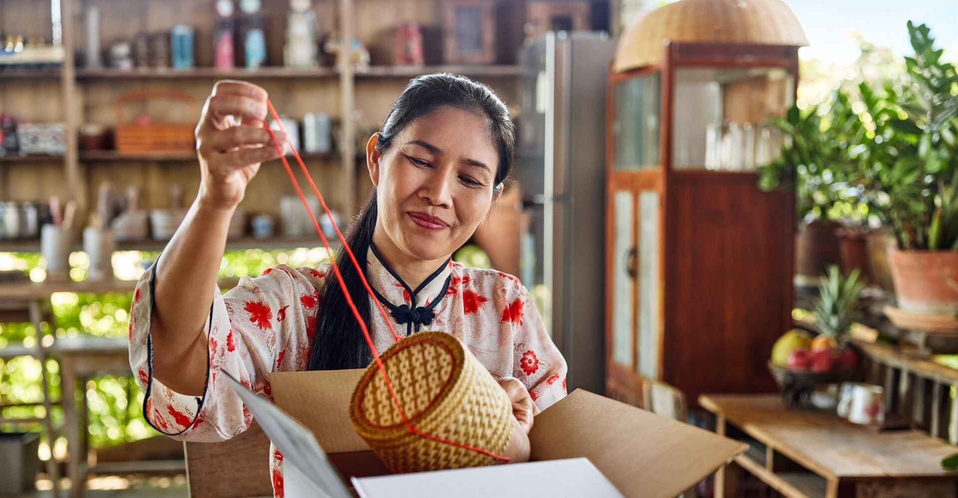 business owner from cambodia packing a fragile item for shipping