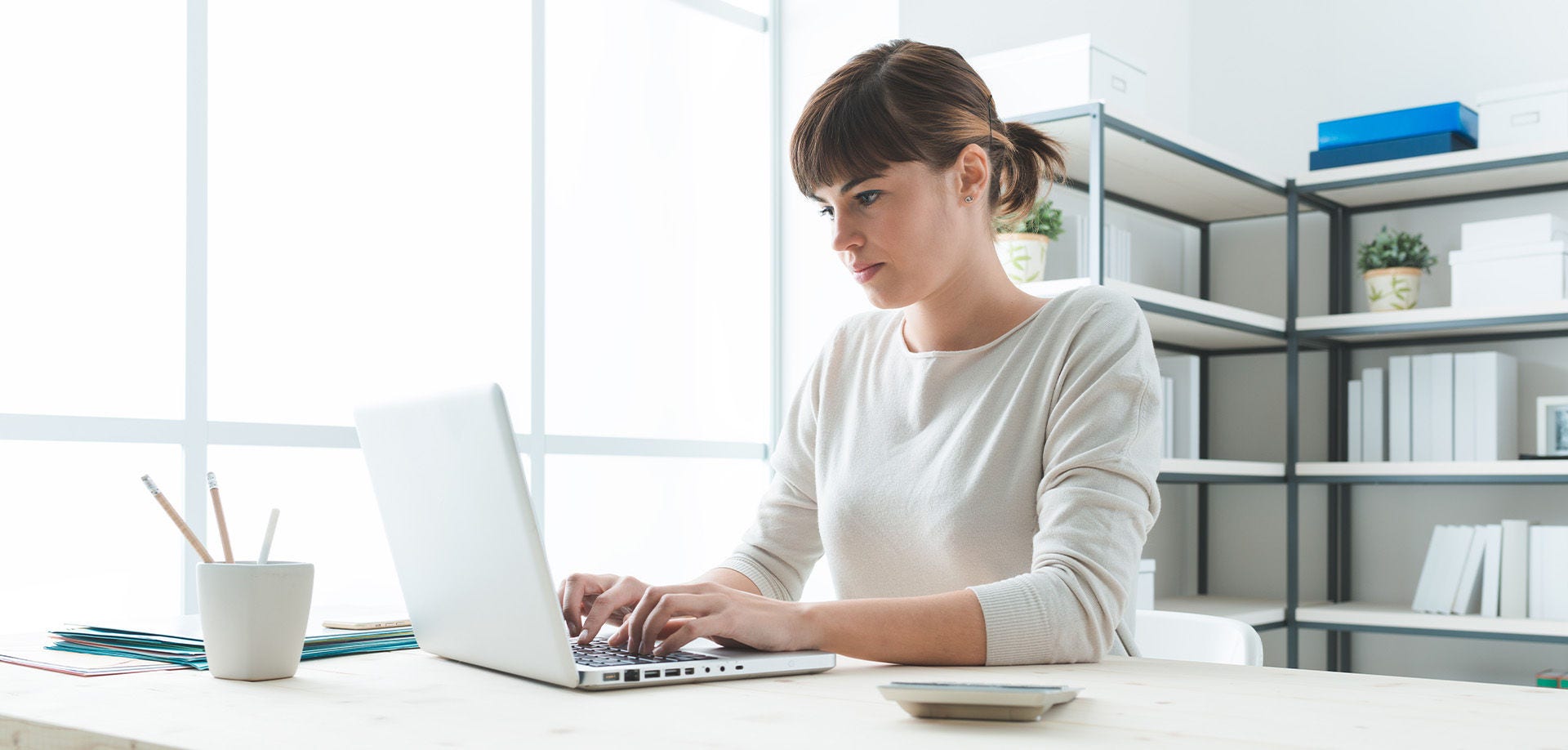woman typing and looking at a laptop screen