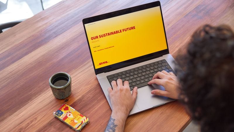 A man looking reading about DHL’s green initiatives.