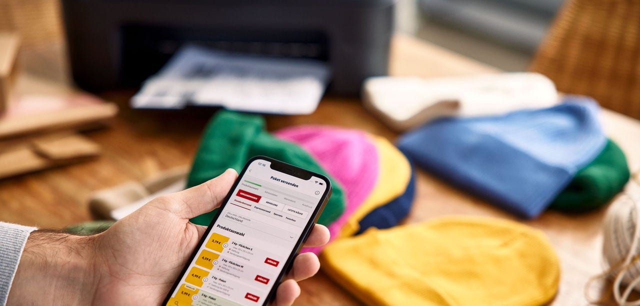 Vendedor organizando pelo celular os pedidos do e-commerce antes da expedição