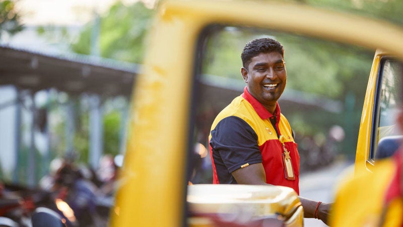 dhl express courier smiling and entering his van