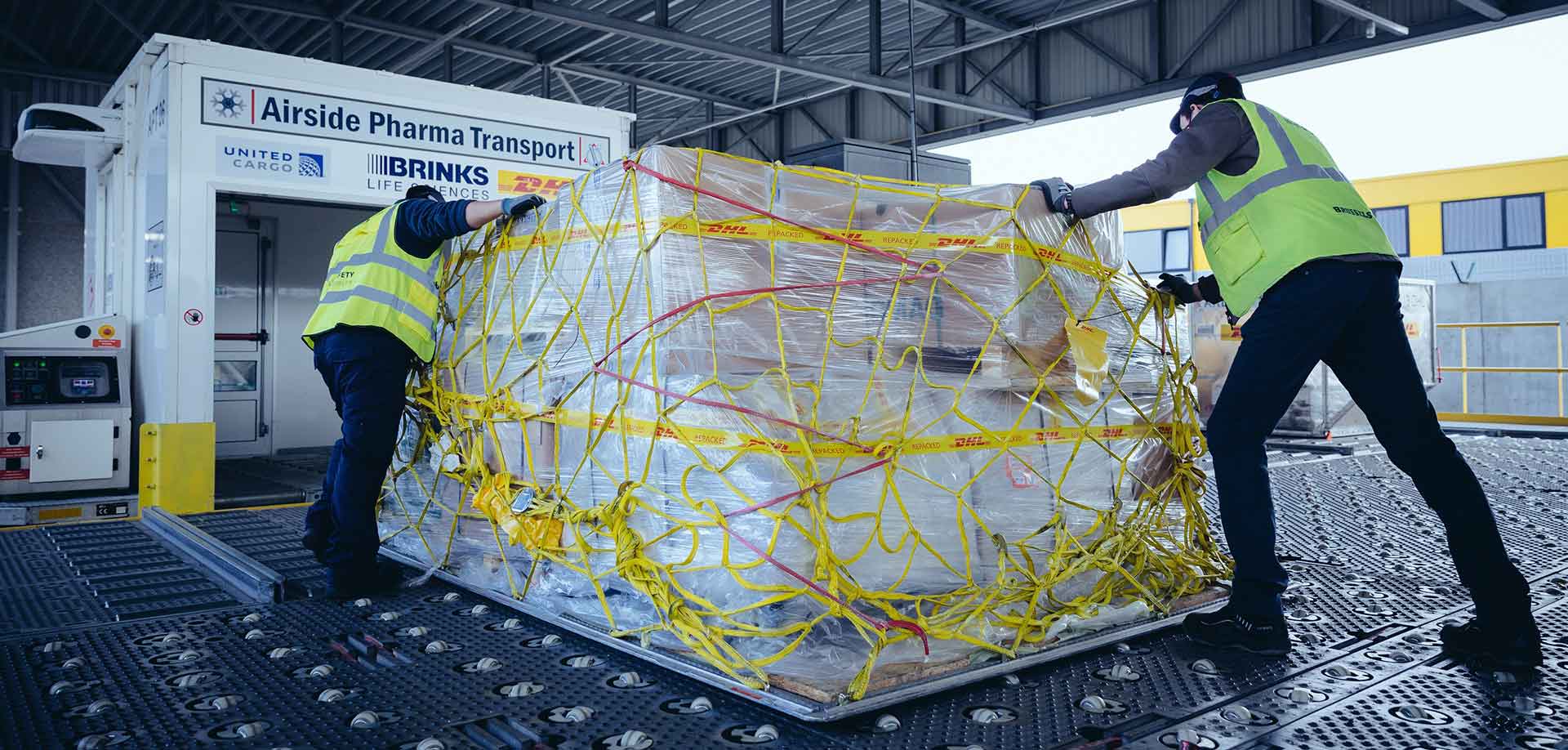 DHL delivery men packing Covid vaccine cargo