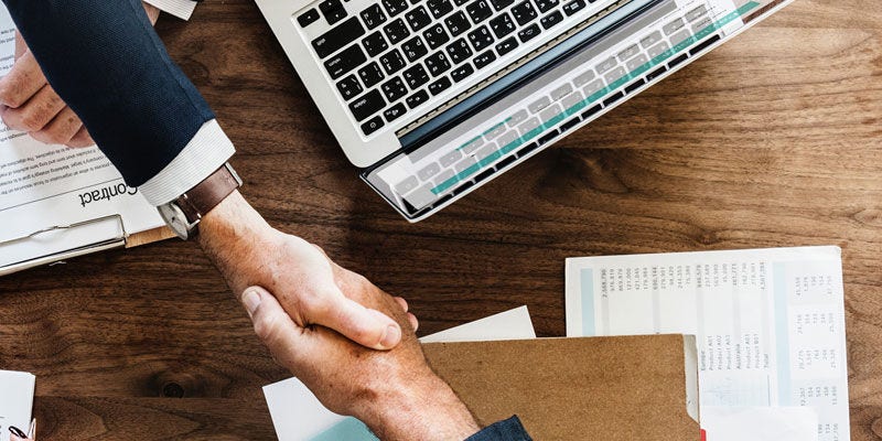 Dva muži si potřásají rukama 