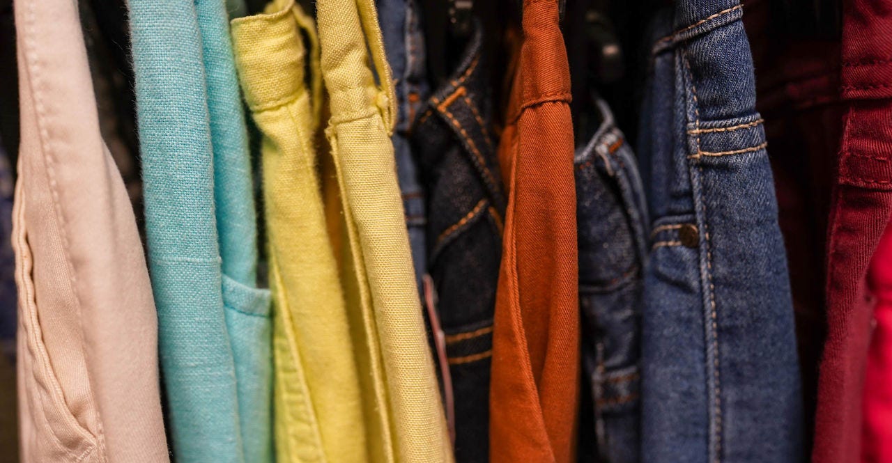 Clothes jeans on a hangers in the store second hand