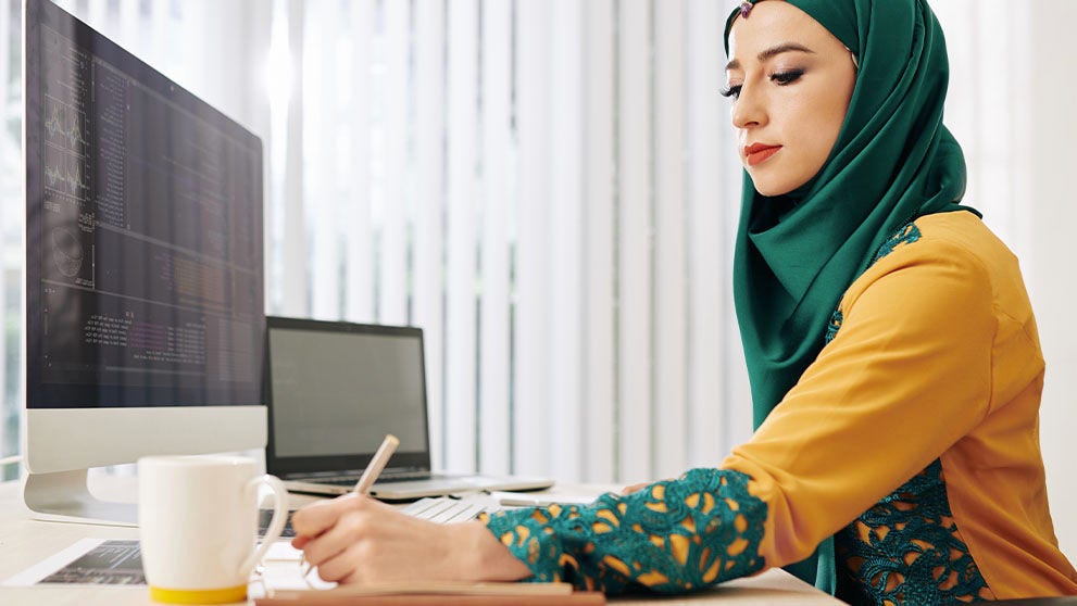 woman in hijab writing