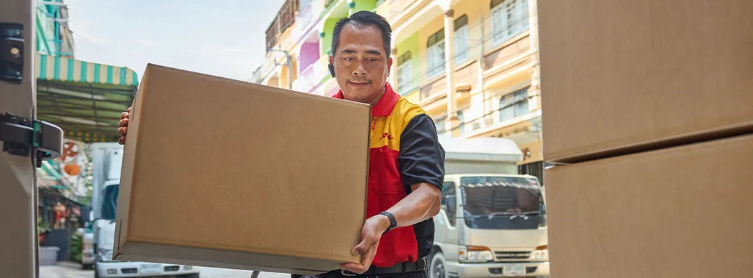DHL courier carrying brown box