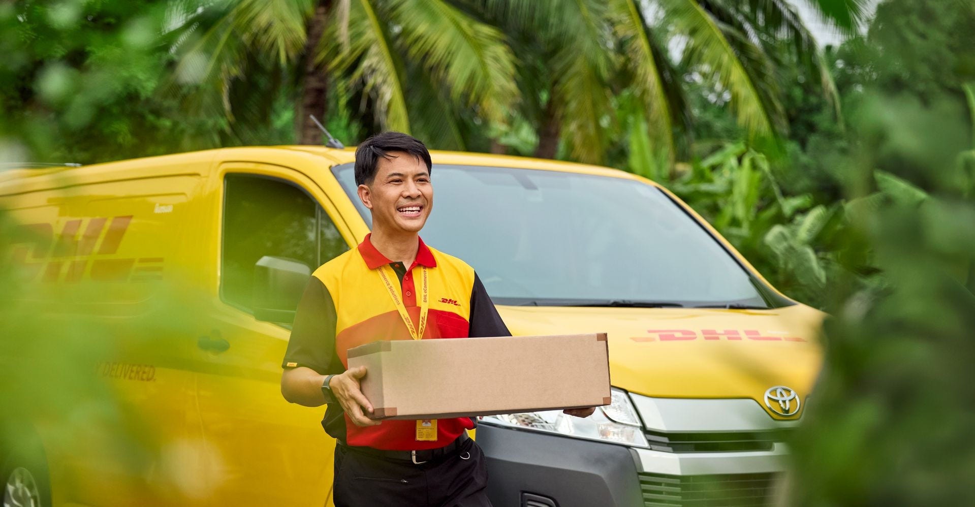 DHL Express employee delivering parcel with DHL van