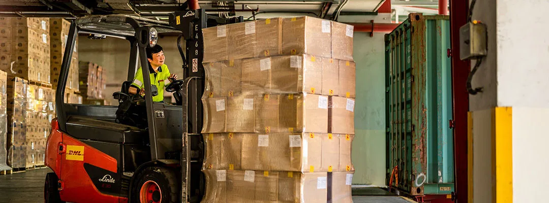 woman driving forklift with a pallet on it