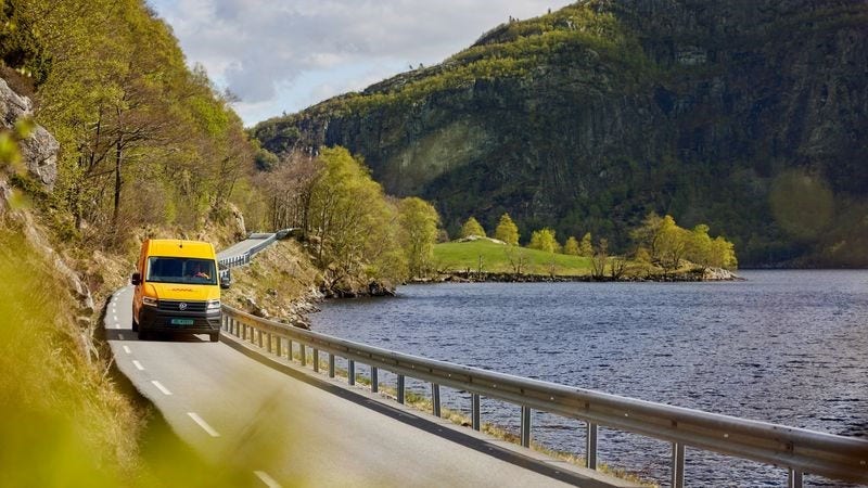 DHL delivery van driving by a lake