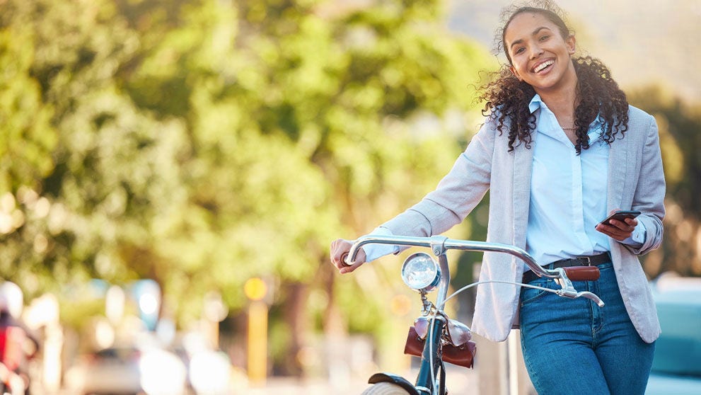 woman smiling holding a bicycle