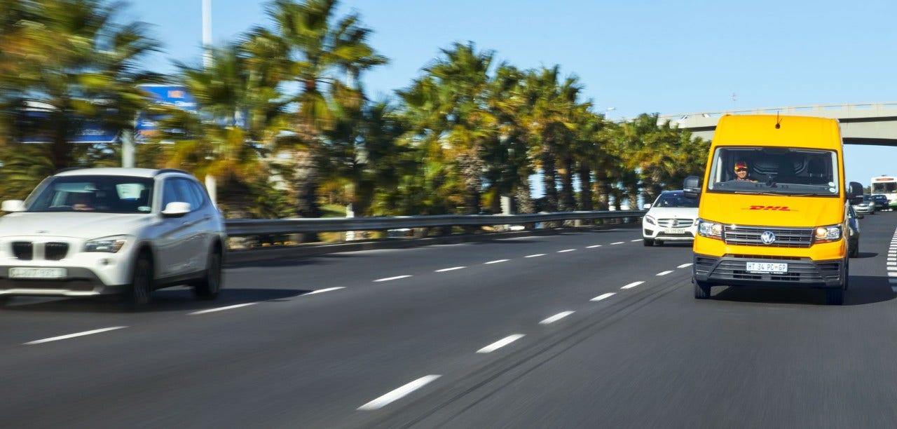 yellow DHL van on a motorway