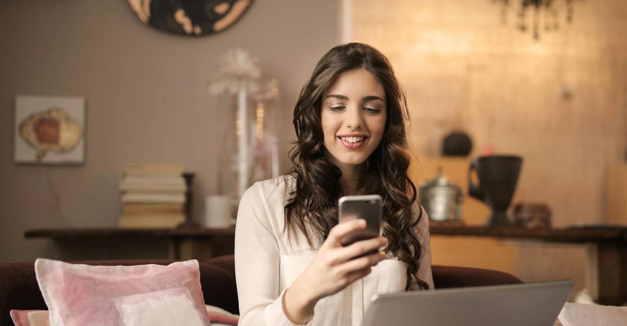 A young woman using her laptop to visit e-commerce pages in her home
