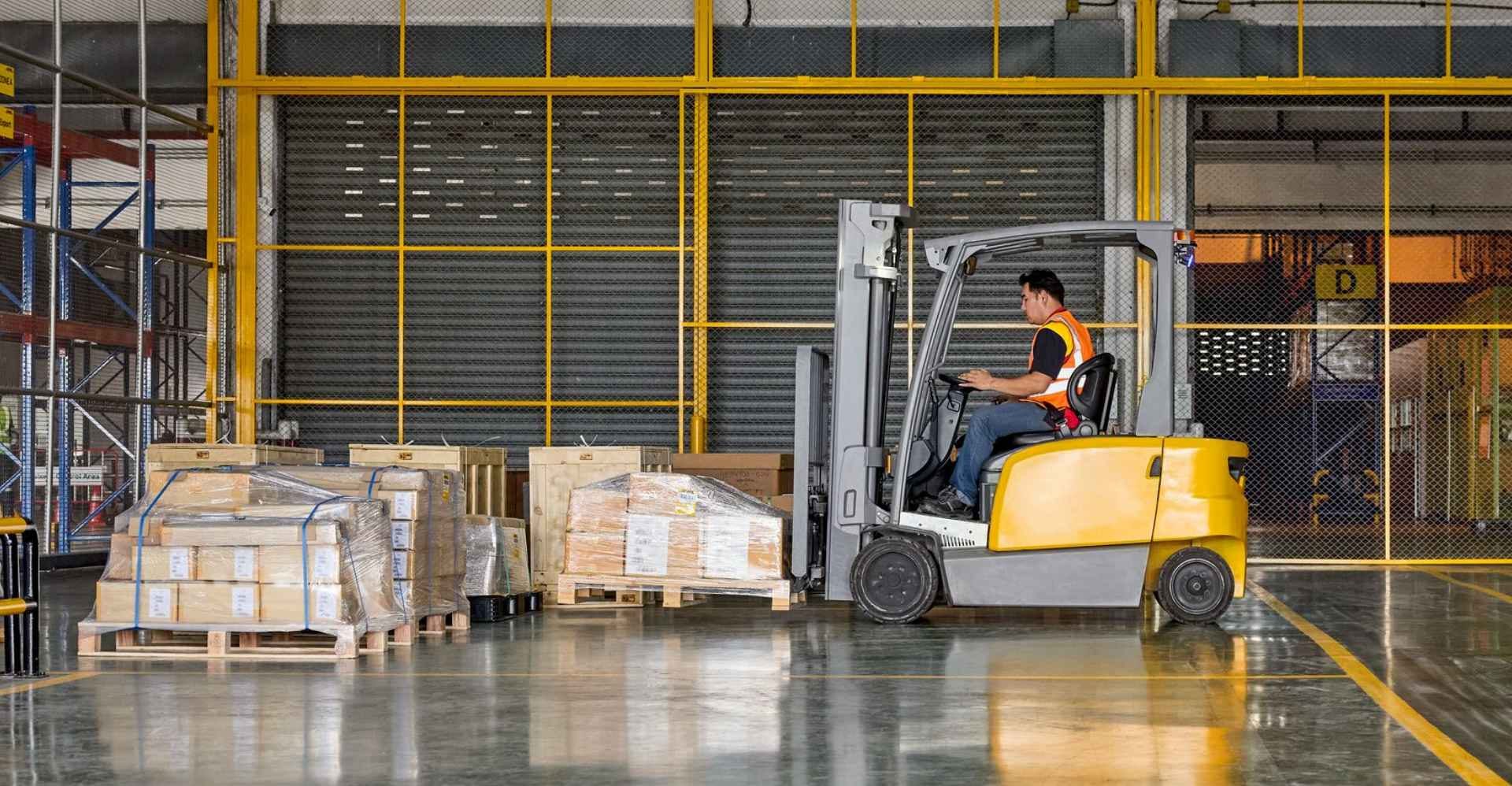 dhl express employee using a forklift to load a pallet box