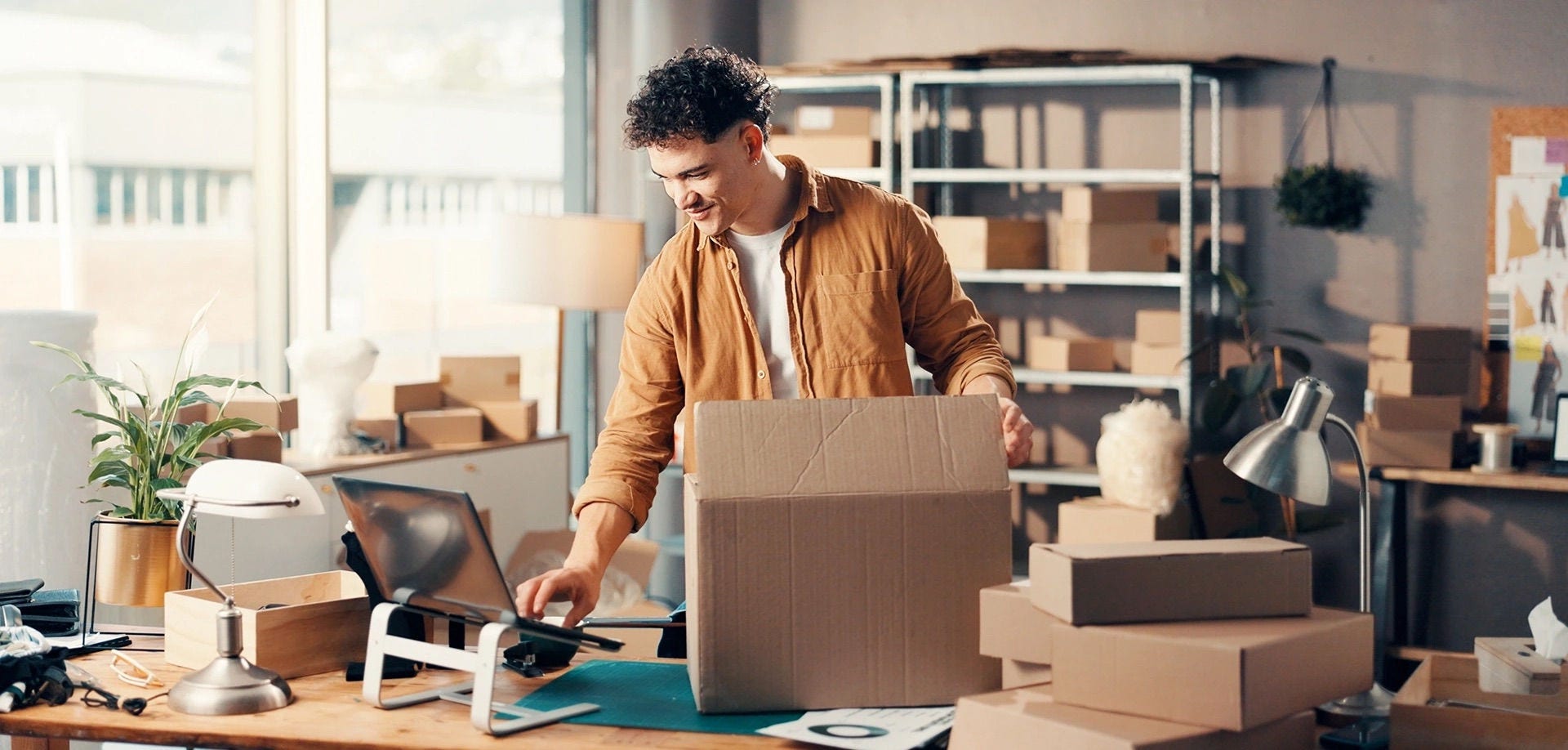 Empreendedor embalando produtos em caixas de papelão para envio