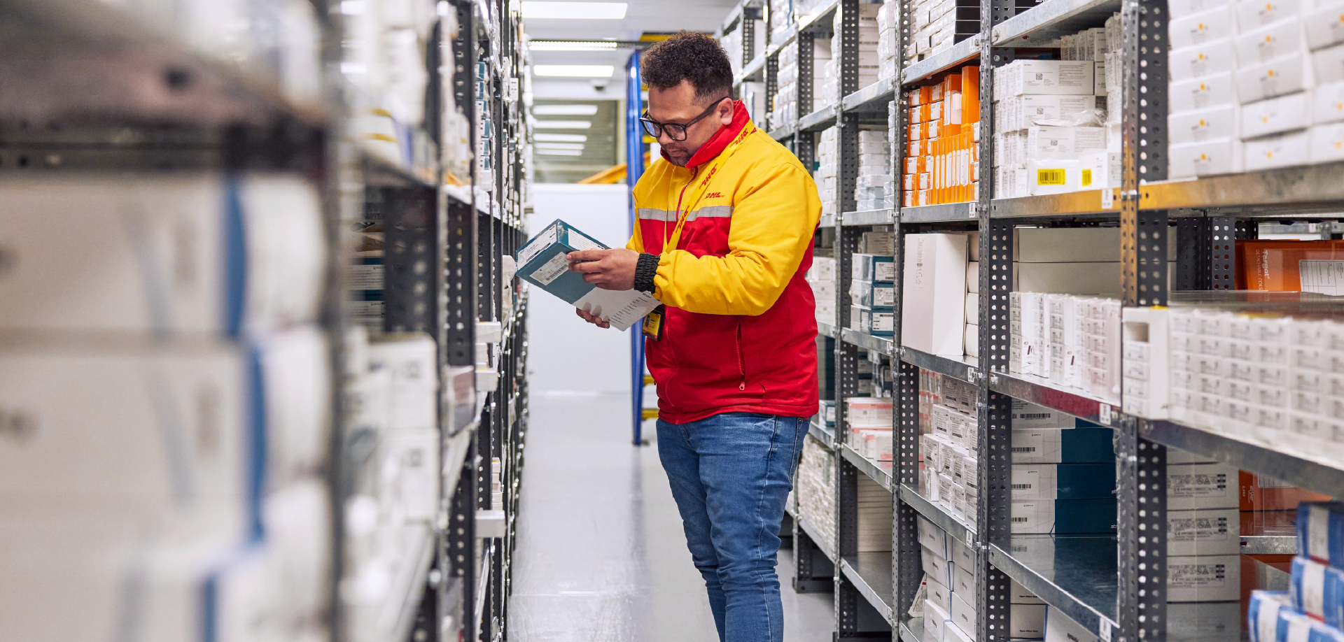 Profissional da DHL confere mercadorias no corredor de um armazém antes da liberação
