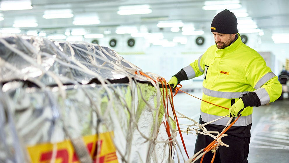 DHL employee tying up a pallet of goods