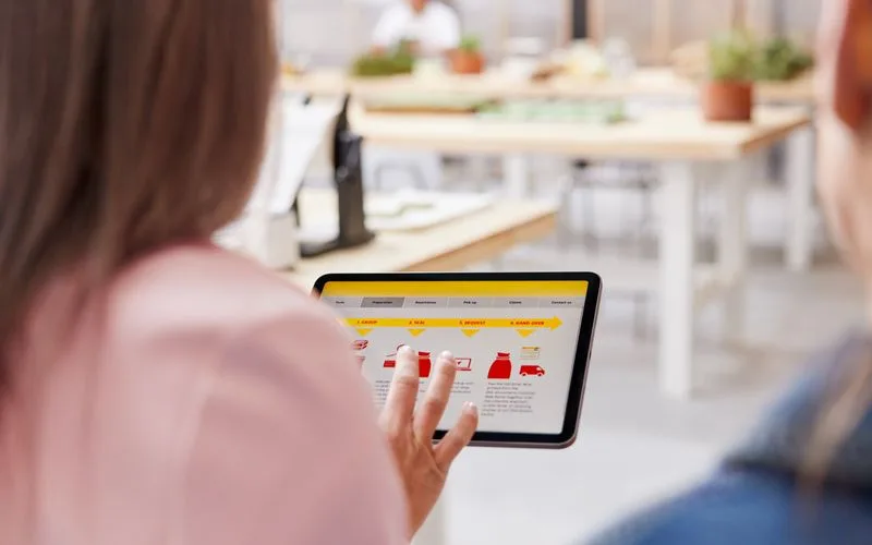a dhl expert introducing shipping solutions to a business owner during a consultation