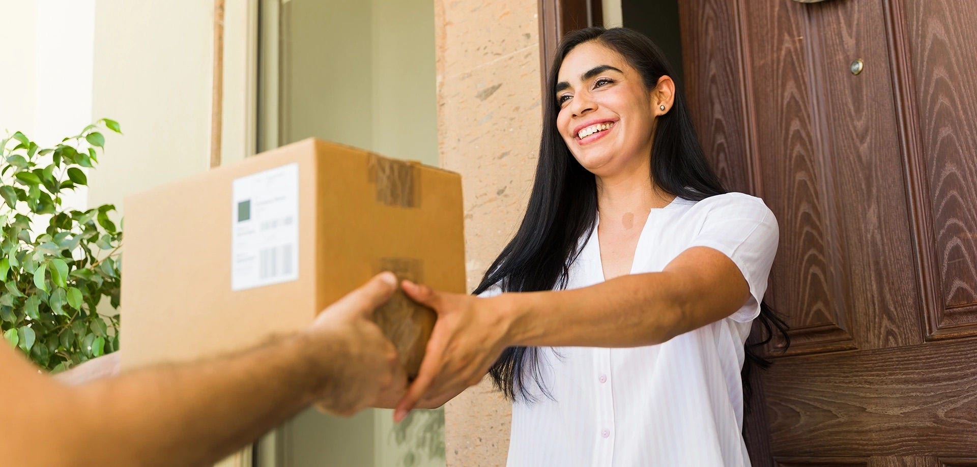 Mulher recebe em casa a encomenda de uma compra internacional