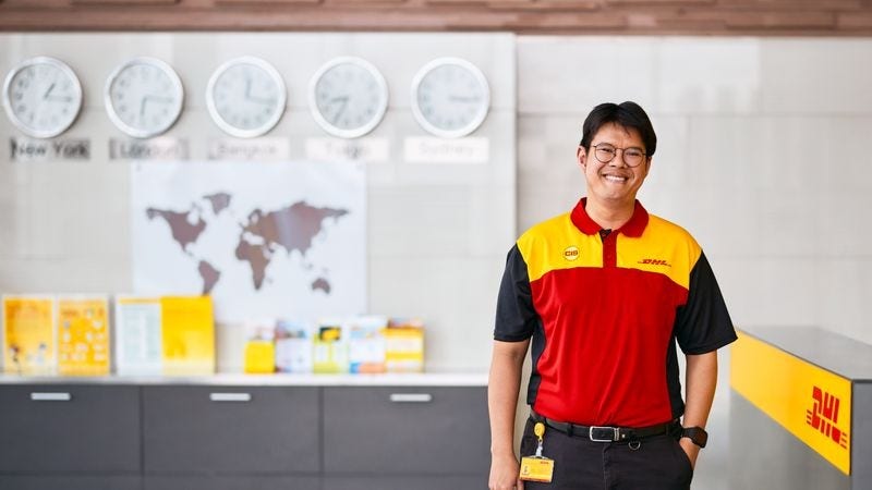 smiling dhl express employee standing for a photo