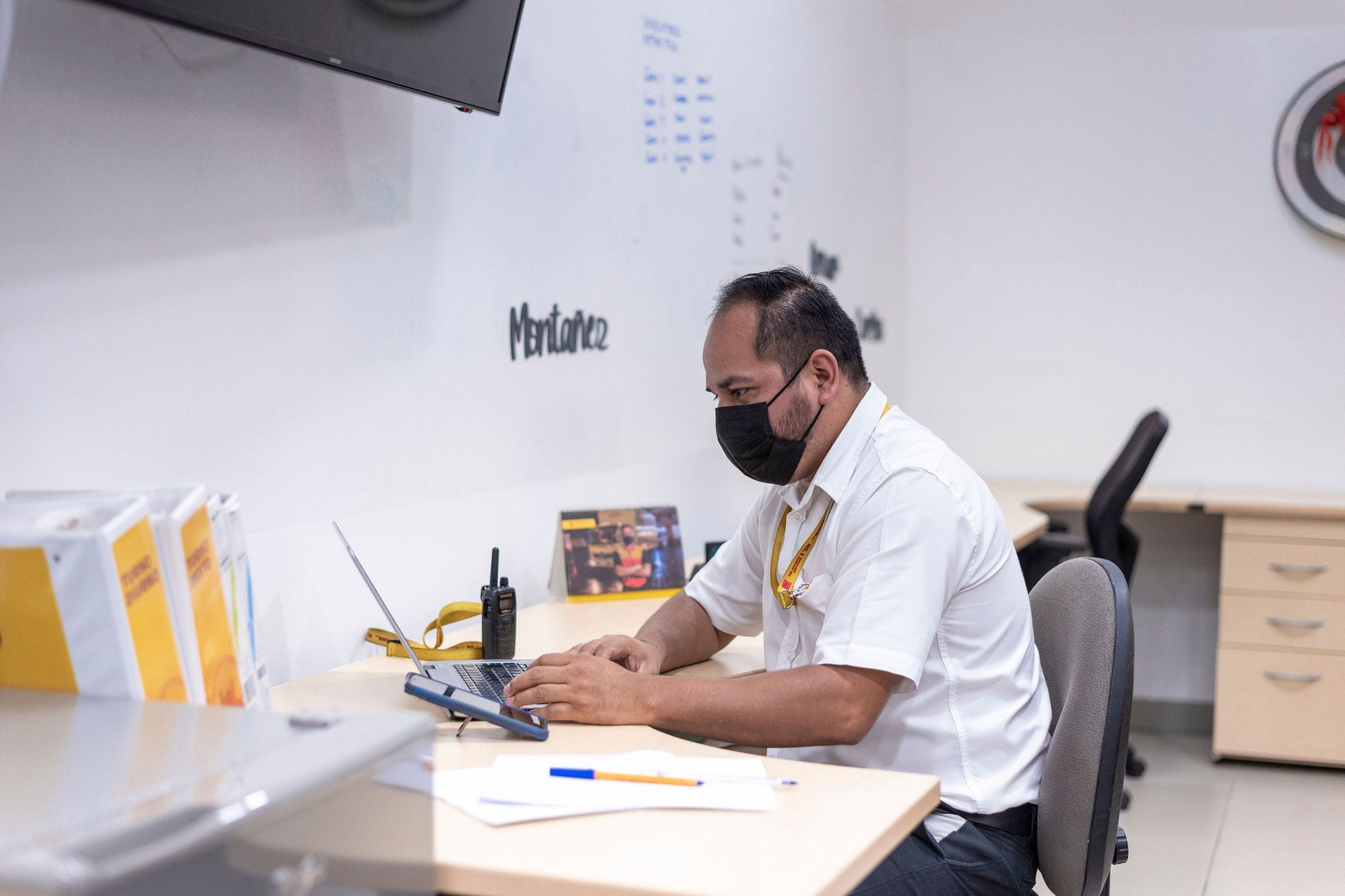 Man in an office writing an email on his computer at work.