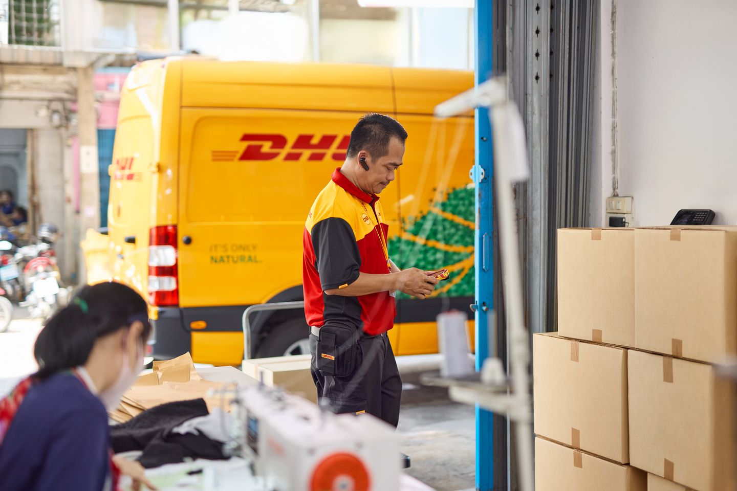 DHL Express courier delivering stocks to a business