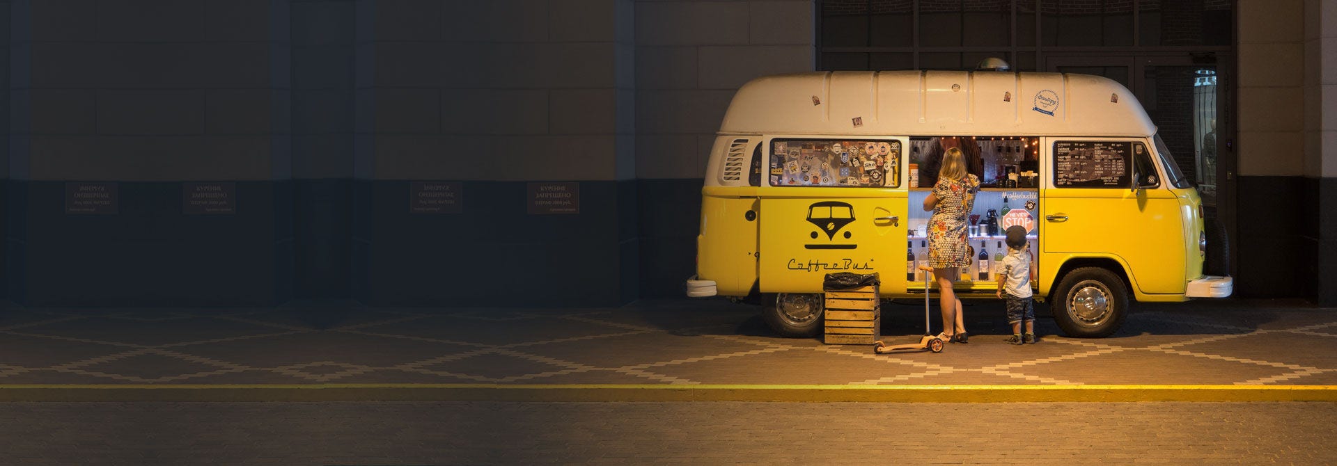 Woman and boy standing outside yellow food van