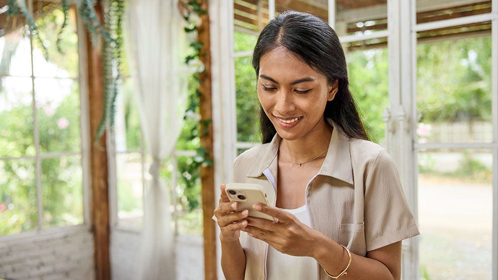woman smiling and scrolling on a mobile phone