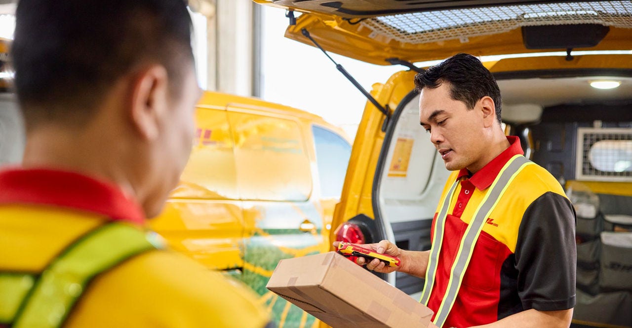 male DHL employee checking shipping label carefully