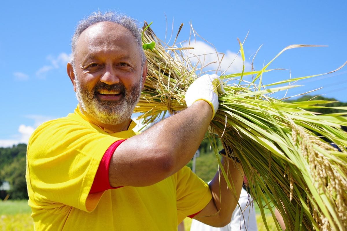 DHL Japan President Tony Khan holding rice bale