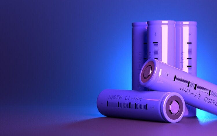 5 cylindrical li-ion batteries type 18650 on the table. Wide dark blue banner with space for text. Rechargeable lithium-ion batteries for electrical devices.